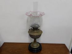 A Victorian brass oil lamp with cranberry tipped v