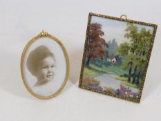 Two gilt photo frames, one holding a fine needlewo