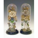 Pair of Victorian silk flower ornaments, each displayed beneath a glass dome Condition: