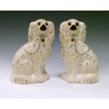 Pair of 20th Century Staffordshire pottery comforter spaniels, each having gilt highlights on an