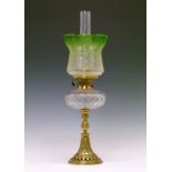 Late 19th/early 20th Century oil lamp having a clear cut glass reservoir, cast brass base having a