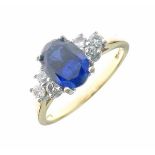 Sapphire and diamond 18ct gold ring, the oval cut sapphire, 8mm x 6mm x 3.6mm deep, with a trio of