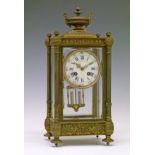 Late 19th/early 20th Century French brass cased four glass mantel clock, surmounted with a classical