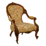 Victorian carved walnut framed open arm drawing room chair upholstered in floral patterned simulated