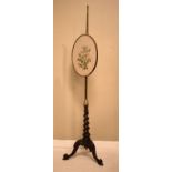 Victorian rosewood and brass pole screen having oval needlework panel on a barley twist column and