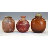 Chinese carved ruby and clear overlaid glass snuff bottles having foliate and animal decoration, a