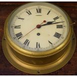 Early 20th Century brass cased ships bulk head clock, the white dial having Roman numerals and