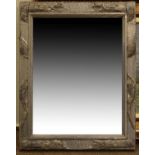 Rectangular metal clad framed mirror having relief decoration of mythical serpents Condition: