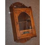 Early 20th Century oak cased wall mounted smoker's cabinet having glazed panel door enclosing pipe