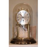 Schatz brass anniversary clock beneath a glass dome Condition:
