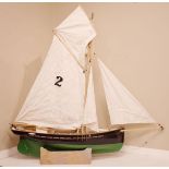 Single masted model yacht having fibreglass hull and wooden fittings, length of hull 125cm, together