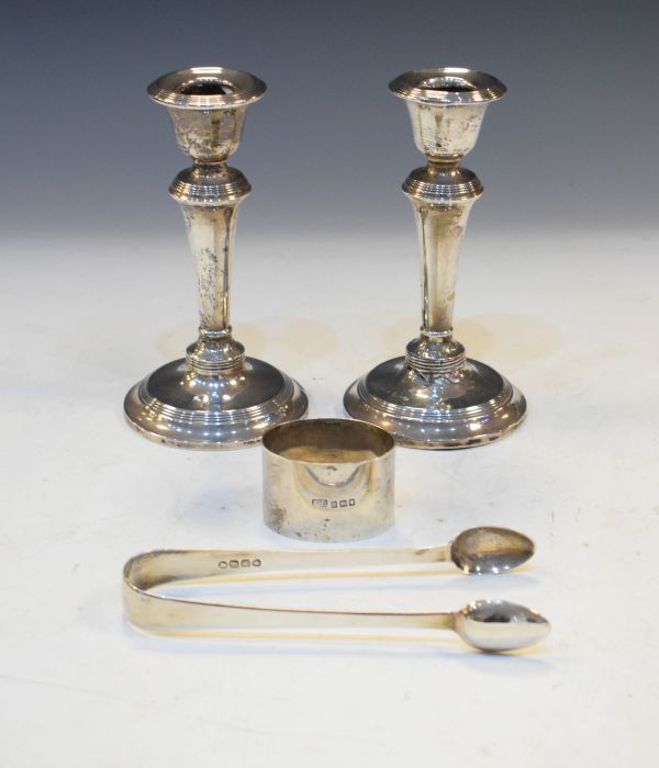 Pair of Edward VII silver weighted candlesticks, Chester 1908, a pair of silver sugar tongs and a