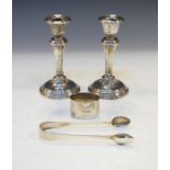 Pair of Edward VII silver weighted candlesticks, Chester 1908, a pair of silver sugar tongs and a