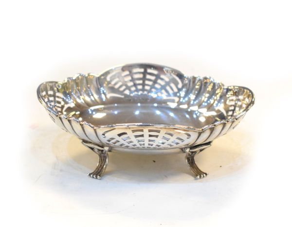 George V silver pierced oval bon bon dish raised on four scroll feet, Birmingham 1926, approx 1.