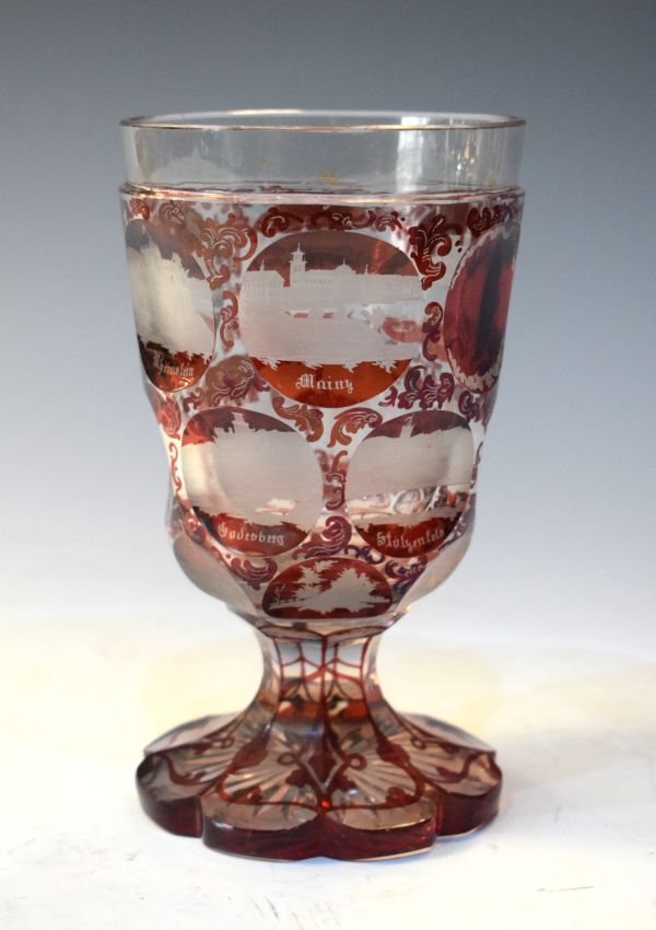 Bohemian ruby cased glass goblet with etched decoration of named city landmarks within the roundels,