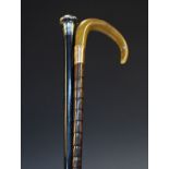 Silver top ebonised cane, and a horn top cane with gold coloured metal band Condition: