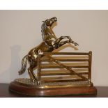 Brass ornament of a horse leaping a five bar gate, on a mahogany plinth Condition: