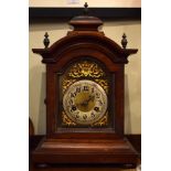 Late 19th Century walnut cased mantel clock having arched brass dial with silvered chapter ring