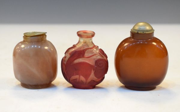 Chinese carved ruby and clear overlaid snuff bottle having foliate and animal decoration, a