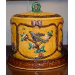 Majolica cheese dome and cover decorated with birds amongst foliage in relief on a mustard ground
