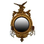 Regency gilt framed circular convex wall mirror having eagle pediment, conforming acanthus