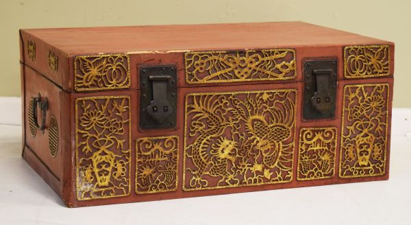 20th Century Oriental trunk having hinged cover, the red lacquer effect finish with blind fretwork