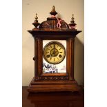 Late 19th/early 20th Century carved walnut cased mantel clock, the off-white dial with Roman