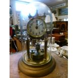 Brass 365 day clock under a glass dome Condition: