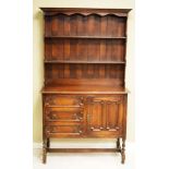 1920's period oak Jacobean Revival dresser, the plate rack fitted two shelves, the base fitted three