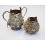 Indian silver two handled sugar basin and cream jug, each piece decorated with birds and animals