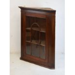 19th Century mahogany hanging corner cabinet fitted three shelves enclosed by a glazed door having