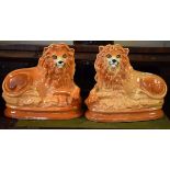 Pair of 19th Century Staffordshire pottery figures of recumbent lions, each having glass eyes