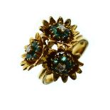 Modernist style triple flowerhead ring set diamonds and green stones, the yellow metal shank stamped