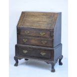 1920's period oak bureau, the fall flap opening to reveal a fitted interior, three long drawers