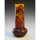 Galle style glass vase decorated with a silhouette landscape on a deep red and yellow ground