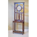 1920's period oak hallstand, the raised back fitted circular bevelled mirror and standing on