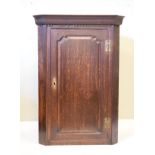 George III oak hanging corner cupboard fitted four shaped shelves enclosed by a fielded panelled