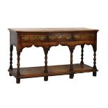 George III oak low dresser, fitted three drawers, shaped apron below, standing on six bobbin