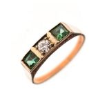 Dress ring set central diamond flanked each side by an emerald coloured stone in a square rubover