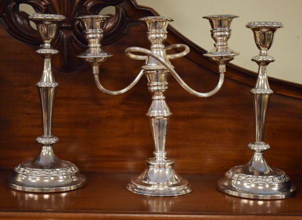 Pair of silver plated candlesticks and a similar three branch candelabra Condition: