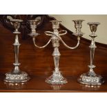 Pair of silver plated candlesticks and a similar three branch candelabra Condition: