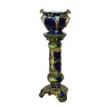 Late 19th/early 20th Century pottery jardinière and stand having Neo-classical scroll decoration