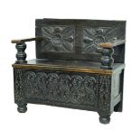 Part antique carved oak hall settle, the wide arms supported by heavy turned columns, fitted