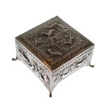 Eastern square embossed white metal box and cover decorated with wild animals, on four splayed