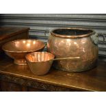 Large oval copper vessel having two cast metal handle loops, together with two other copper pans