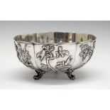 Chinese silver circular bowl decorated with birds and foliage in relief and standing on triple