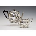 Victorian silver oval teapot and two handled sugar basin, each having part fluted decoration and