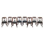 Eight Victorian Athenaeum style walnut spoon back dining chairs, each having a carved pierced