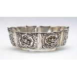 Chinese silver oval bowl decorated with six reserves having dragons in relief on an orange peel