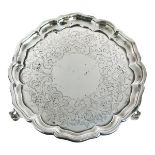 Victorian engraved silver salver having a pie-crust edge and standing on triple pierced scroll feet,